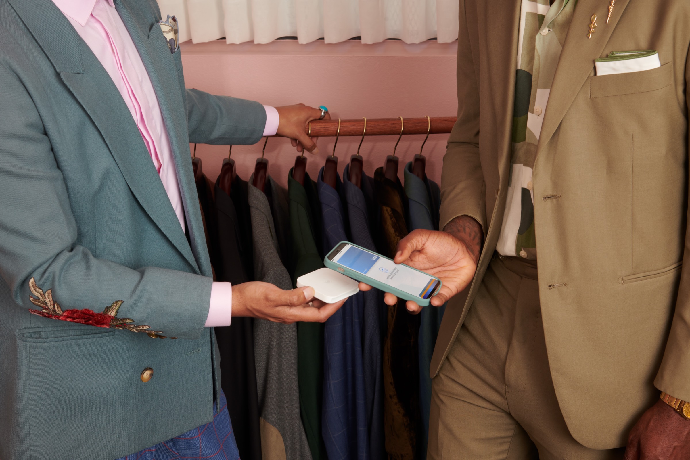 A shop owner handing a purchase to a customer at the counter