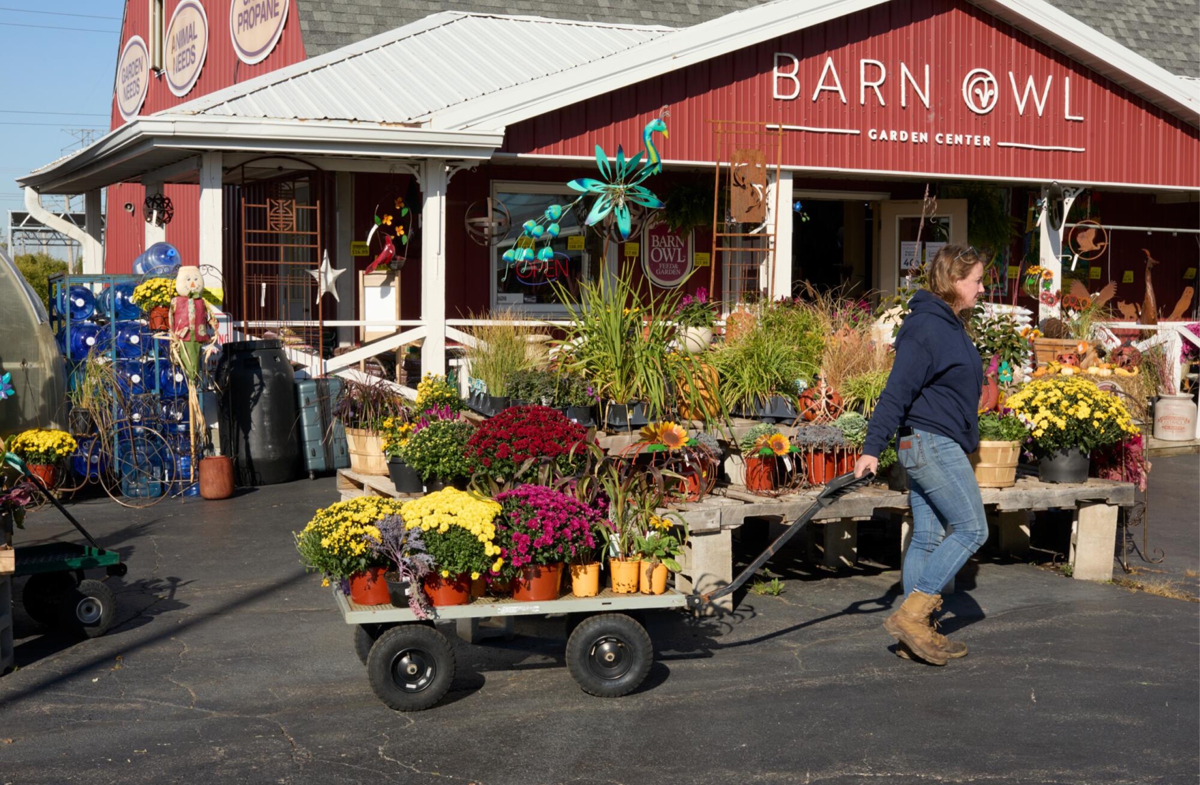 A garden centre with a trader wheeling a cart of plants