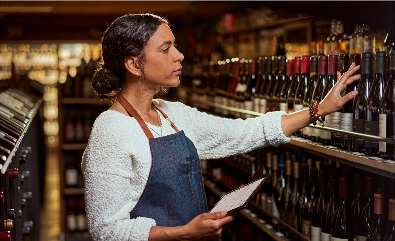 A shopkeeper checking stock on a tablet
