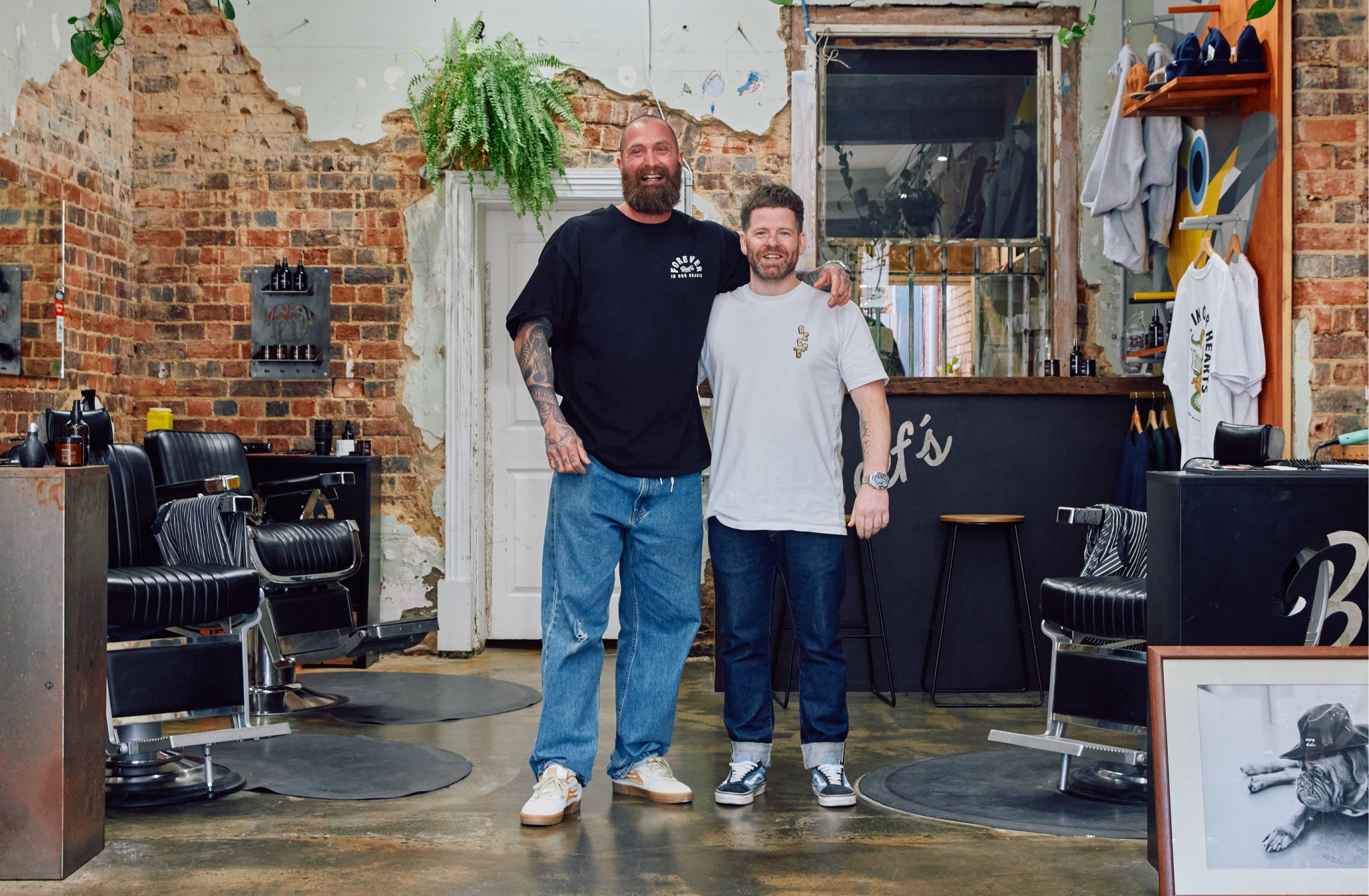 Two barbers standing in the shop they run together