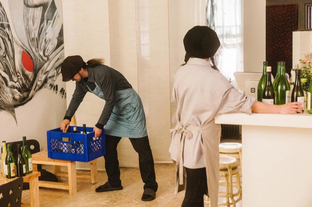 Two people preparing products before a shop opens